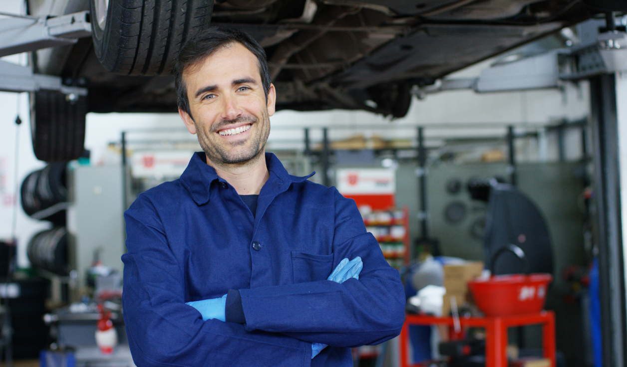 Trabalhador sorrindo com carro de fundo